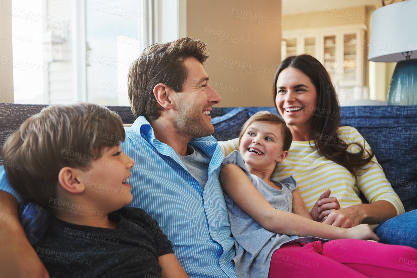 Buy stock photo Love, parents and relax with kids on sofa for bonding together, healthy relationship and security. Happy family, people and children with laugh in home for funny conversation or connection on weekend
