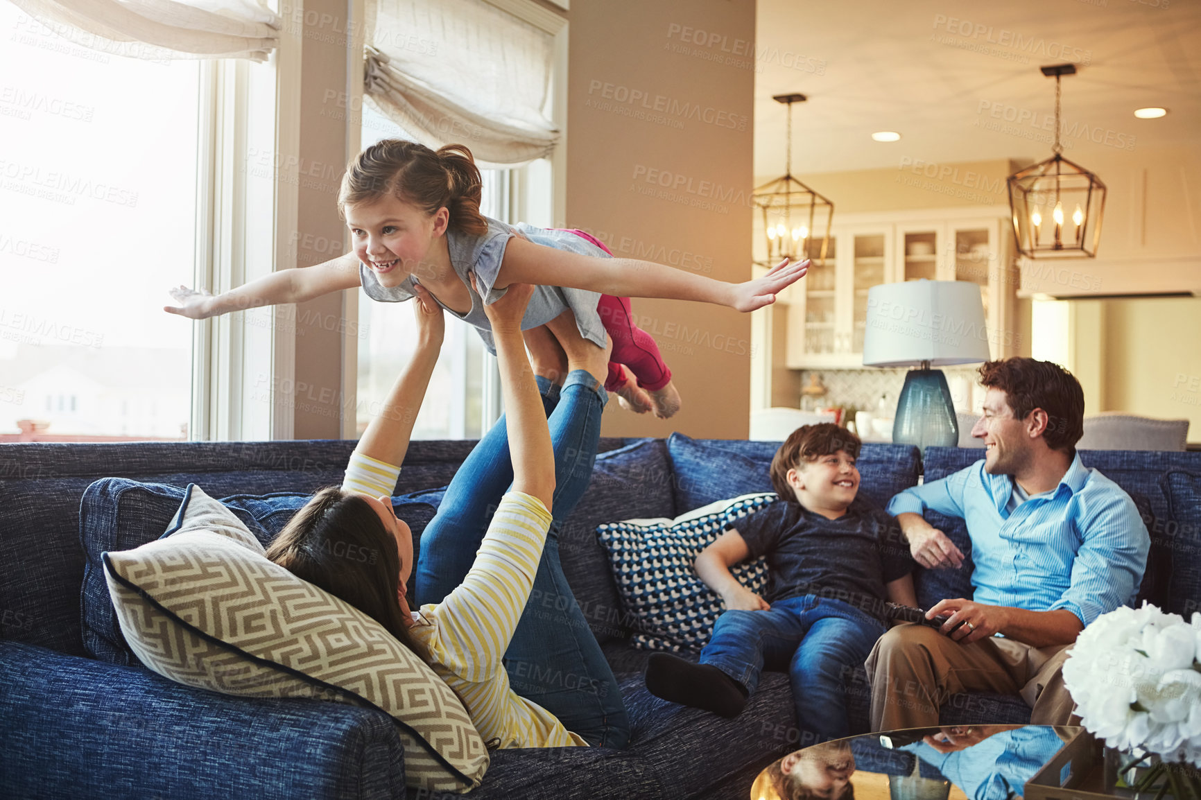 Buy stock photo Airplane, playing and children with parents on sofa in home relaxing with care, happiness and love together. Smile, bonding and girl kid with flying role play with mom, brother and dad in living room