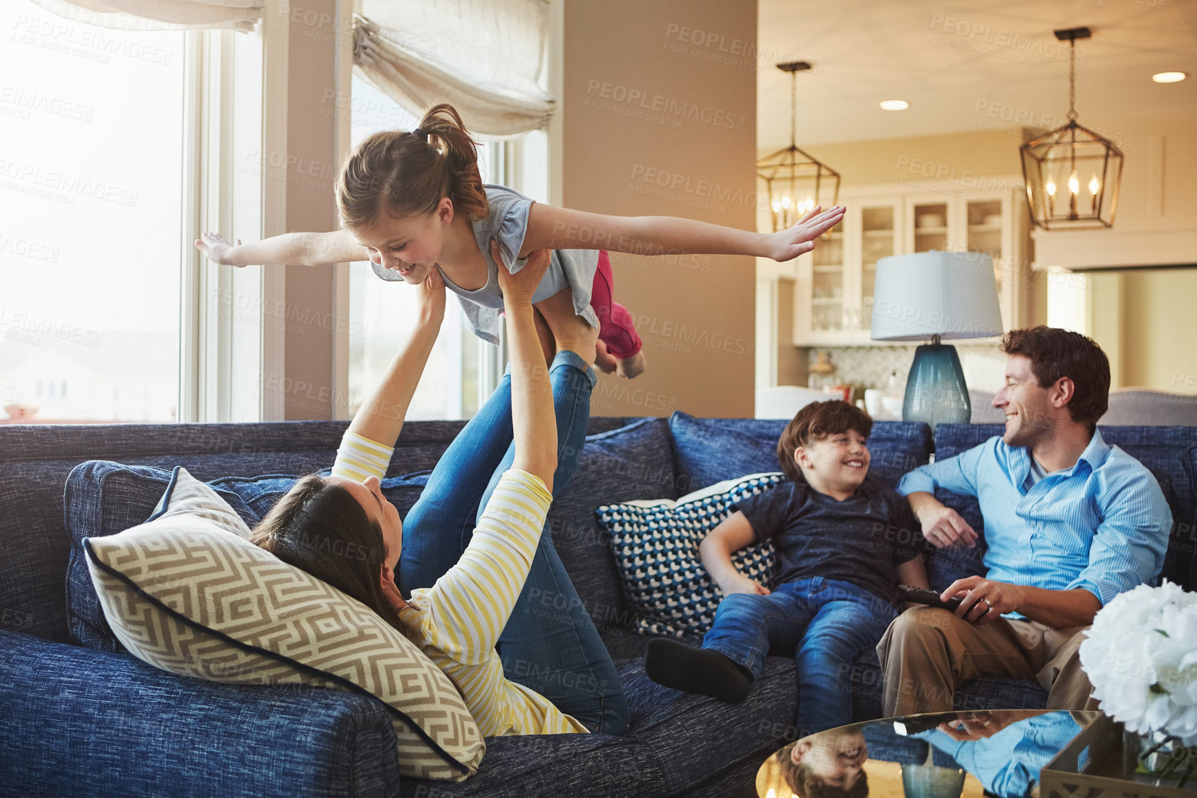 Buy stock photo Airplane, bonding and family on sofa in home relaxing with care, happiness and love together. Smile, playing and girl child with flying role play with mom, brother and dad sitting on couch in house.