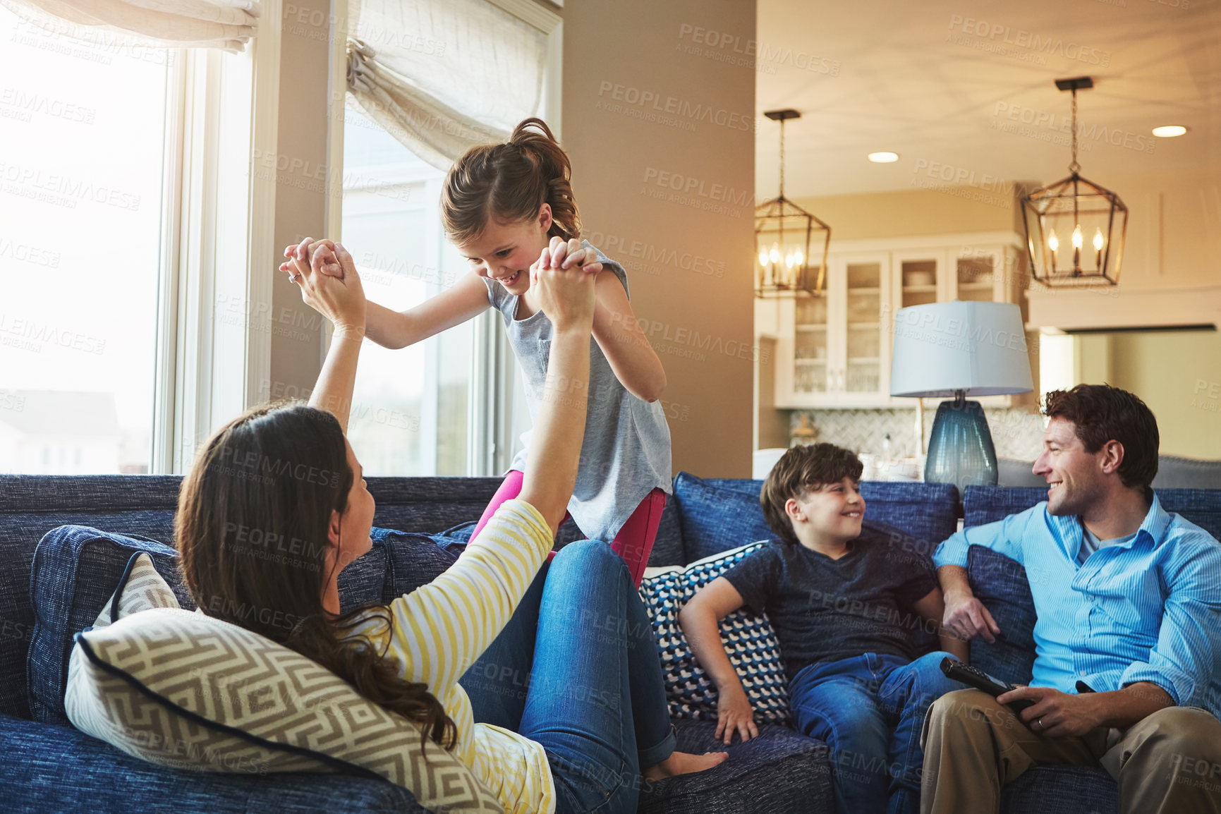 Buy stock photo Happy, playing and kids with parents on sofa in home relaxing with care, fun and love together. Smile, bonding and girl child with mom, brother and dad sitting on couch in living room at family house