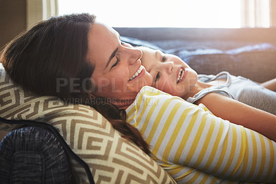 Buy stock photo Love, happy and mom cuddle her child while relaxing on sofa in the living room of their home. Smile, bonding and young mother embracing and her laughing daughter with care in their family house