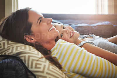 Buy stock photo Love, smile and mother cuddle her child while relaxing on sofa in the living room of their home. Happiness, bonding and young mom embracing and her laughing daughter with care in their family house