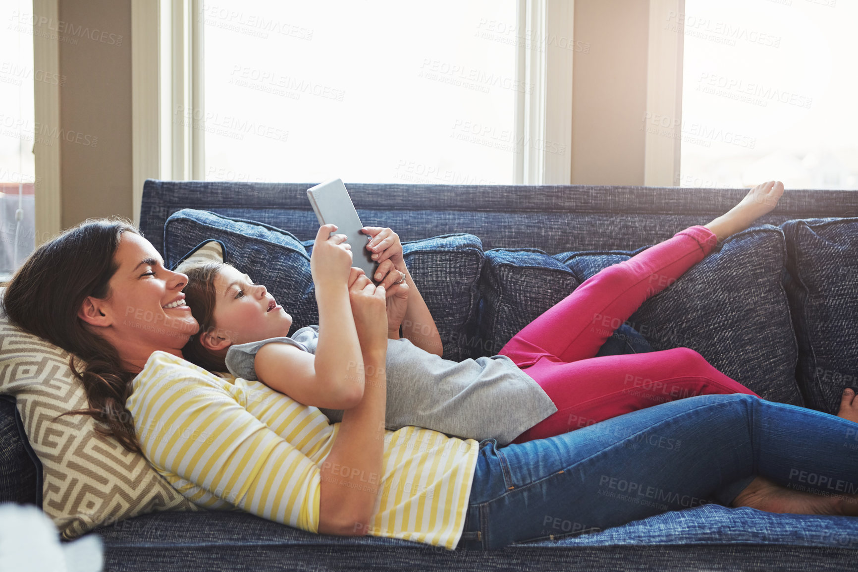 Buy stock photo Happy mom, child or lying with tablet on sofa for online streaming, entertainment or cartoon in home. Mother, kid or daughter with smile on technology for network, app or web subscription in house