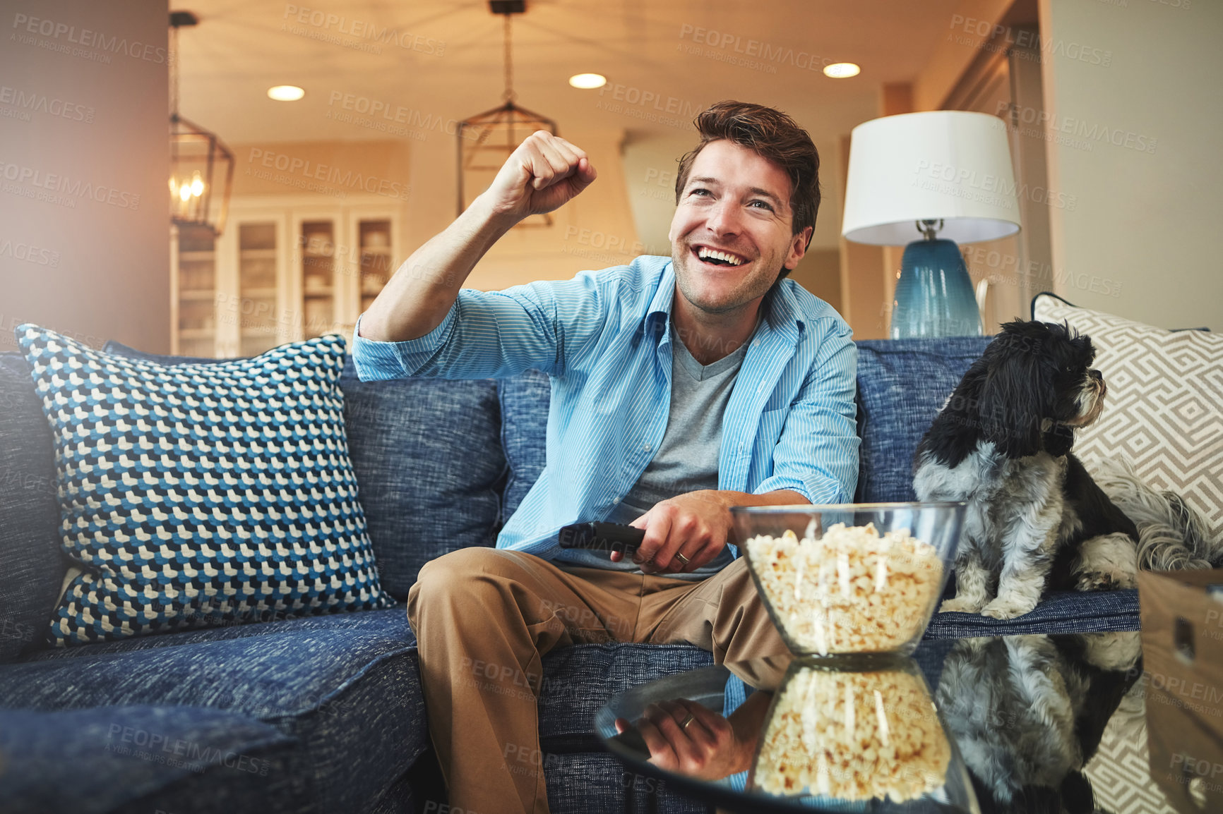 Buy stock photo Celebration, man and television or popcorn in home on sofa with watching sports game, challenge and fun. Living room, couch and excited or happy with dog for tournament, win and entertainment