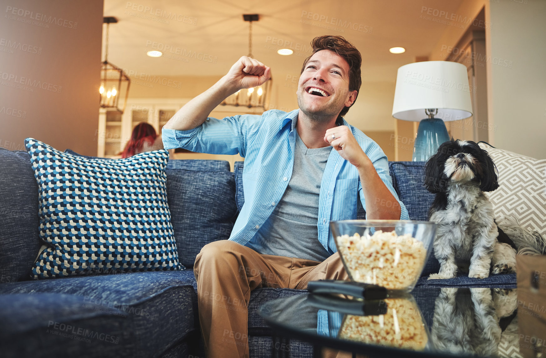 Buy stock photo Excited, man and celebration with watching tv or popcorn in home on sofa with sports game, challenge and fun. Living room, couch and smile or happy with fist with dog for win, tournament or support