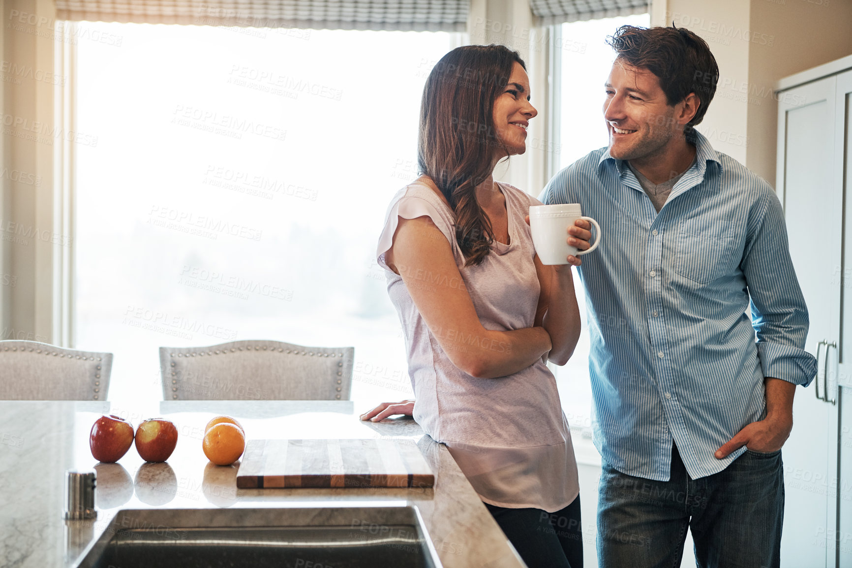 Buy stock photo Happy, love and couple with coffee in kitchen for conversation, bonding and morning chat in their home together. Trust, gossip and calm people in a house with tea break, support or security with care