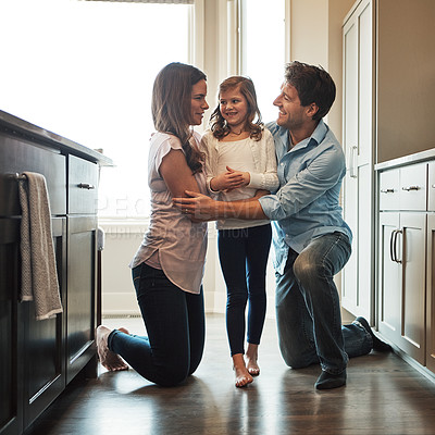 Buy stock photo Parents, girl and embrace in kitchen for love, kid and support for relationship in home. Mother and father, daughter and together in hug for care or security, conversation and bonding in family house