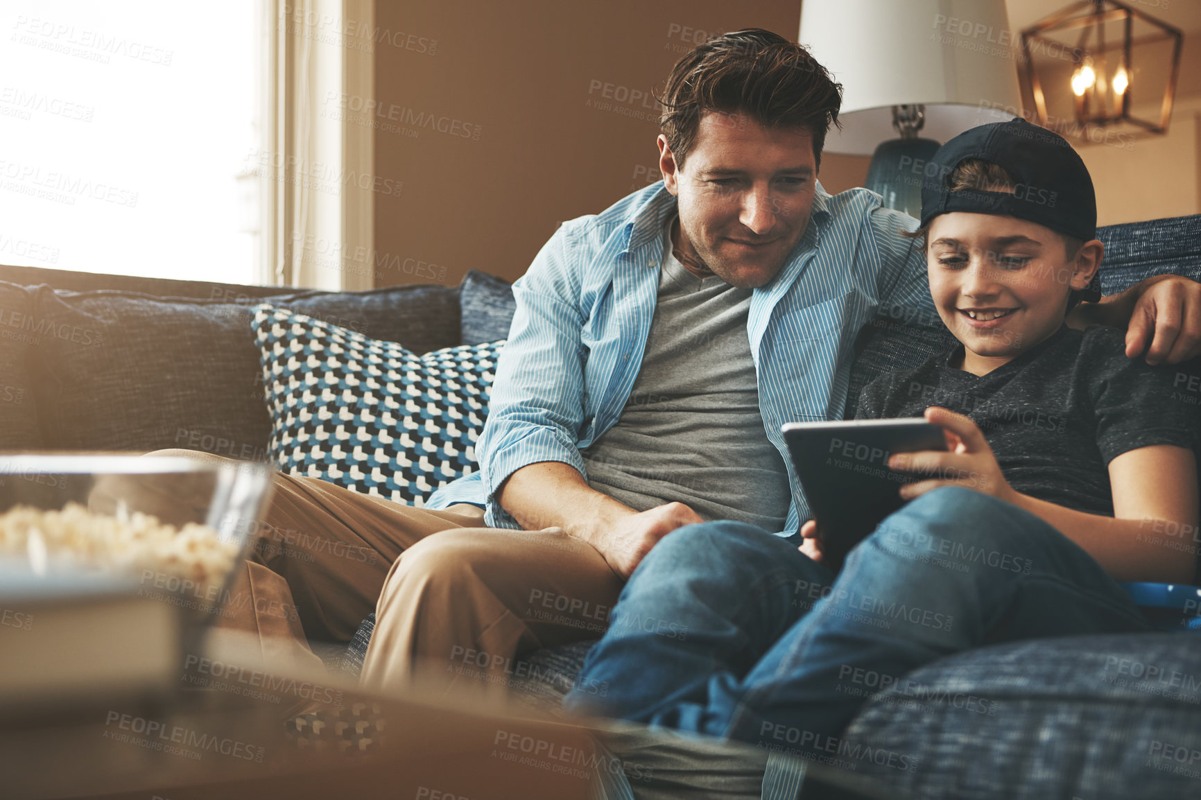 Buy stock photo Dad, son and relax on sofa with tablet for online streaming service, movies or video games on holiday. Excited family, man or father with child in living room with digital tech for e learning at home