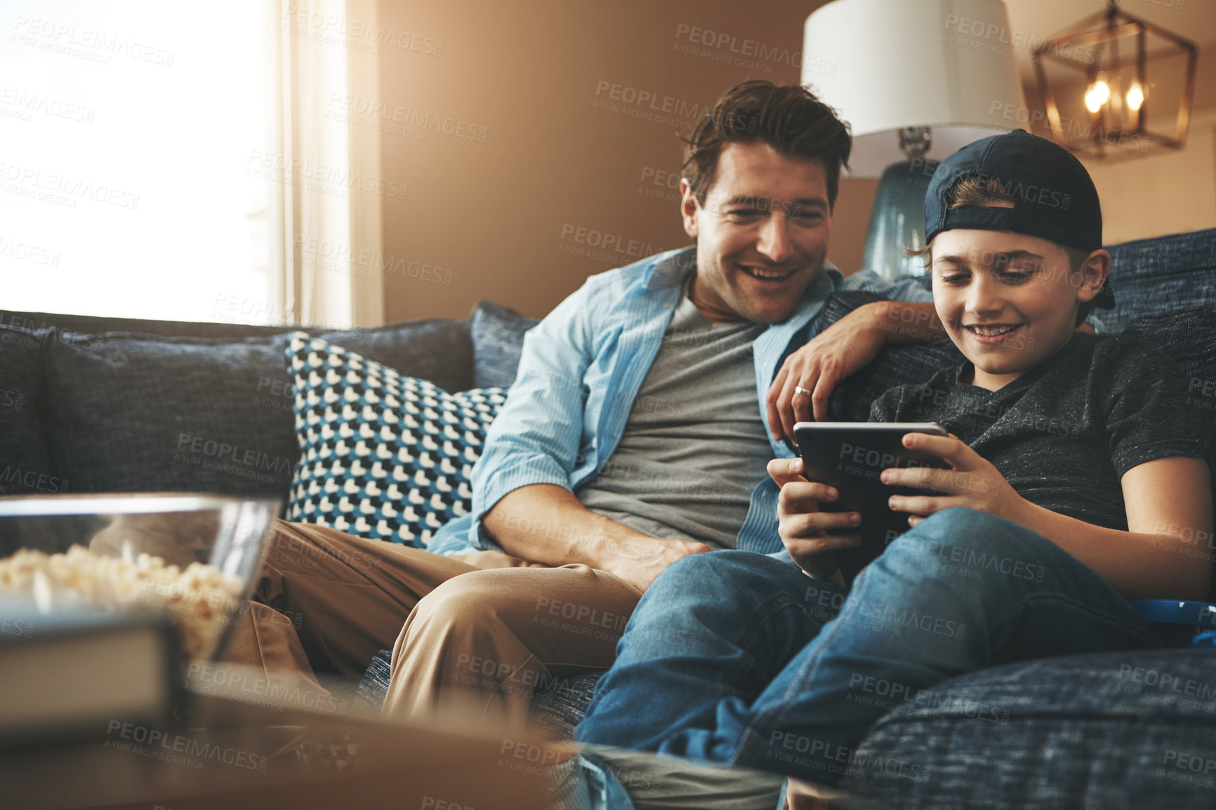 Buy stock photo Father, son and relax on sofa with tablet for online streaming service, movies or video games on holiday. Excited family, man or dad with child in living room with digital tech for e learning at home