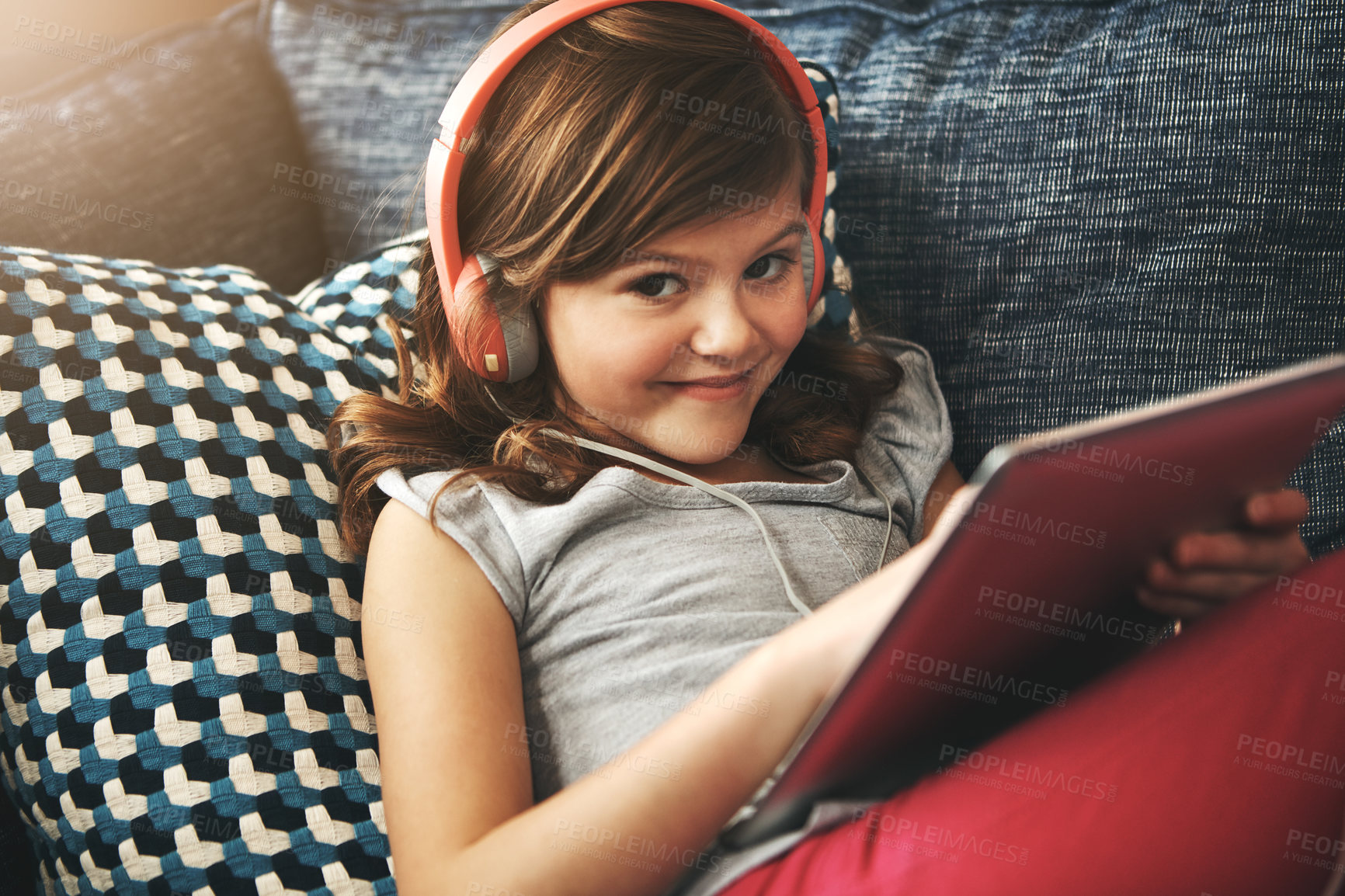 Buy stock photo Portrait of a little girl wearing headphones while using a digital tablet at home