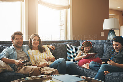 Buy stock photo Technology, happy family together and in living room of their home with lens flare. Connectivity, networking or streaming and parents watching tv with children on tablet or smartphone with headphones