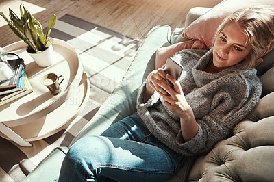 Buy stock photo Top view, woman on sofa and smartphone for connection, social media and chatting in living room. Young female, girl and cellphone for conversation, relax and solitude in lounge on couch and happiness