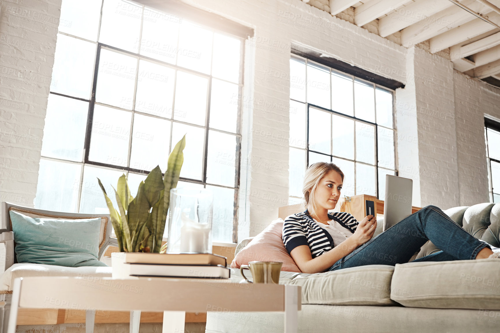 Buy stock photo Thinking, laptop and credit card ecommerce woman on living room sofa for banking information payment check. Relaxed girl on home couch with concentration and focus  for online shopping transaction.