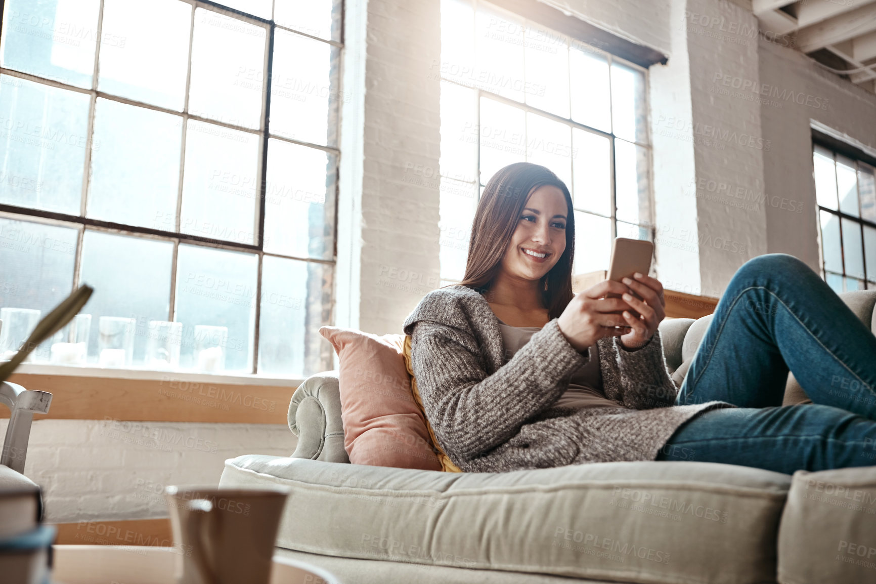 Buy stock photo Home, internet and woman with phone on sofa for online network, communication and notification. Happy, person and thinking with tech in living room for social media, connection and reading message