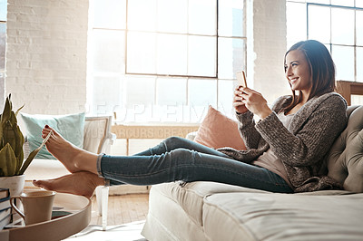 Buy stock photo Woman, smile and relax with smartphone on sofa at home for text message, communication and notification. Happy, person and thinking with tech in living room for internet, connection and social media