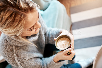 Buy stock photo Shot of a young woman relaxing on the sofa at home with a warm beverage