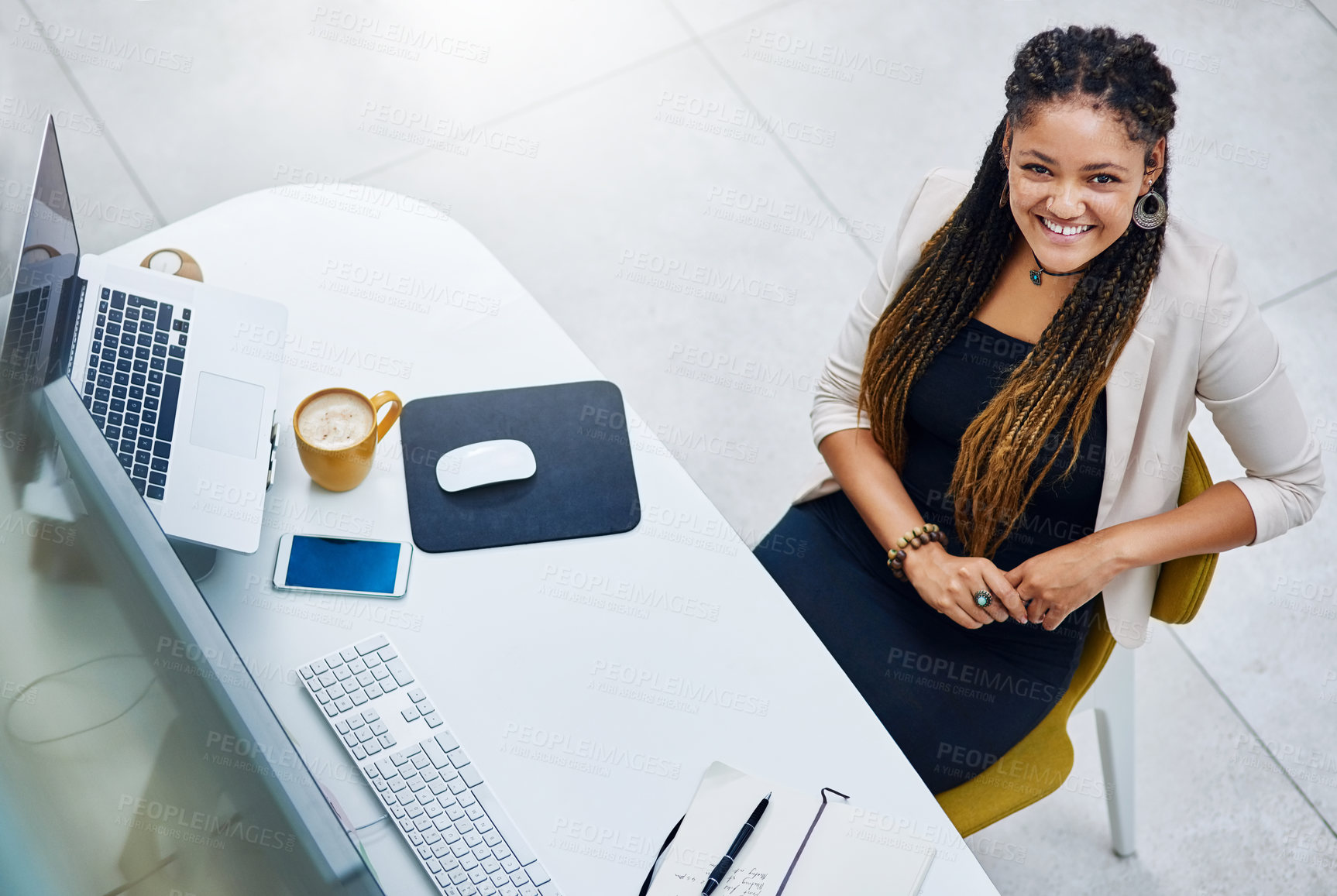 Buy stock photo High angle portrait of an attractive young businesswoman sitting at her desk in the office