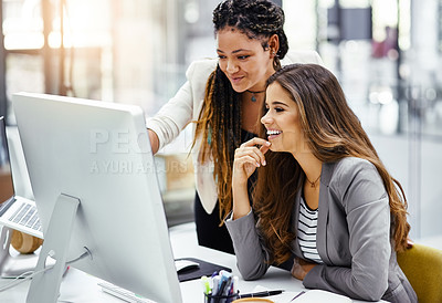 Buy stock photo Cropped shot of two attractive young businesswomen working at a desk in their office