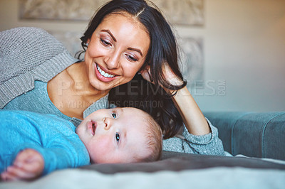 Buy stock photo Shot of a young woman relaxing with her baby boy on the bed at home