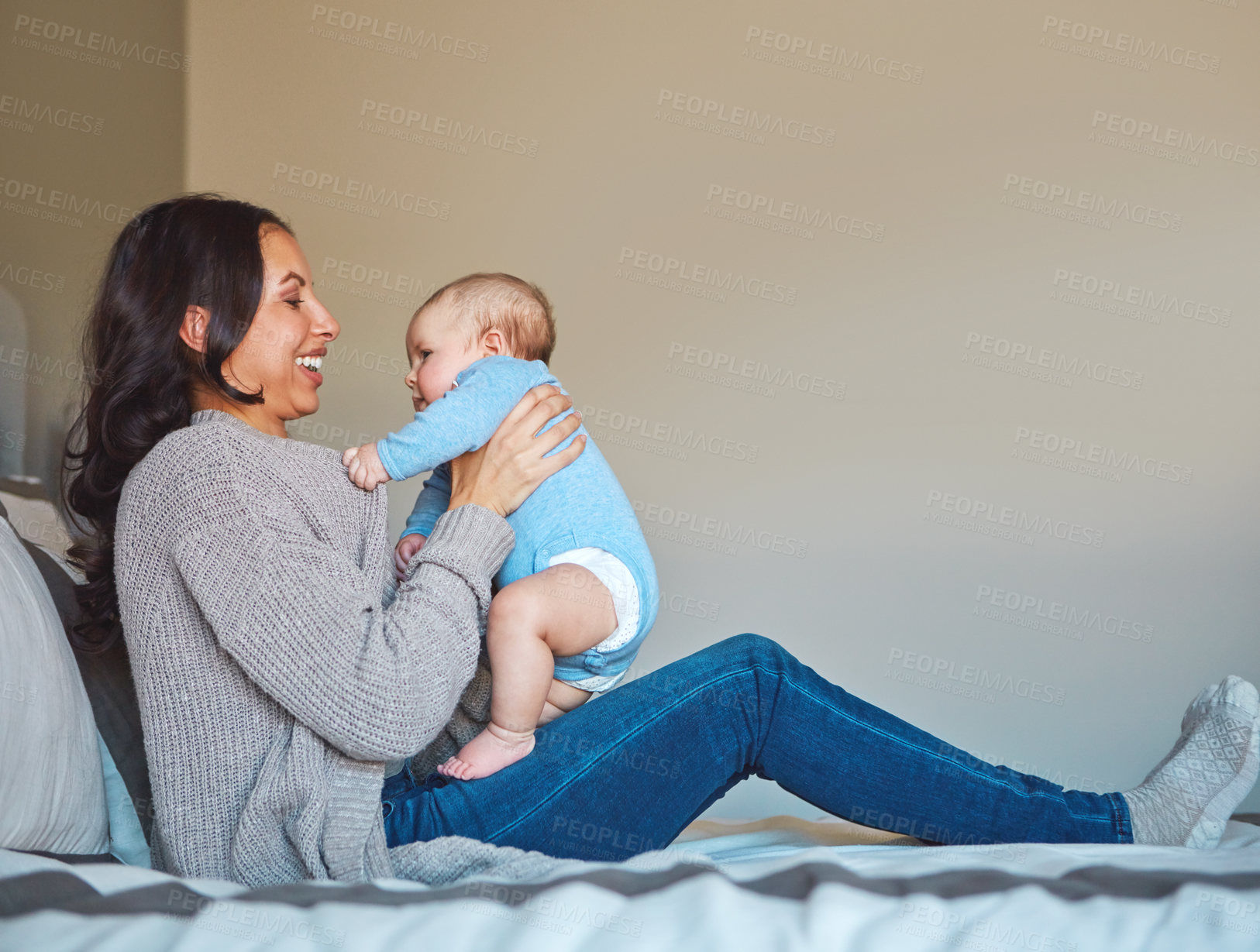 Buy stock photo Shot of a young woman bonding with her baby boy on the bed at home