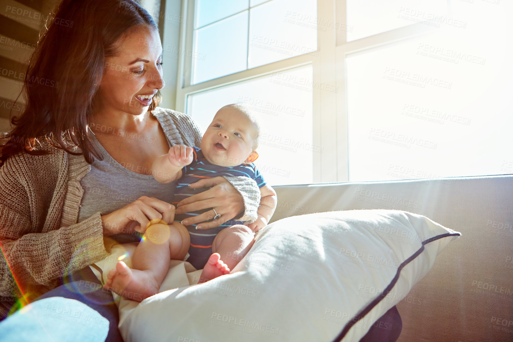 Buy stock photo Shot of a young woman bonding with her baby boy on the sofa at home