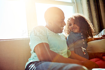 Buy stock photo Shot of a happy little girl and her father having a conversation while relaxing on the couch at home