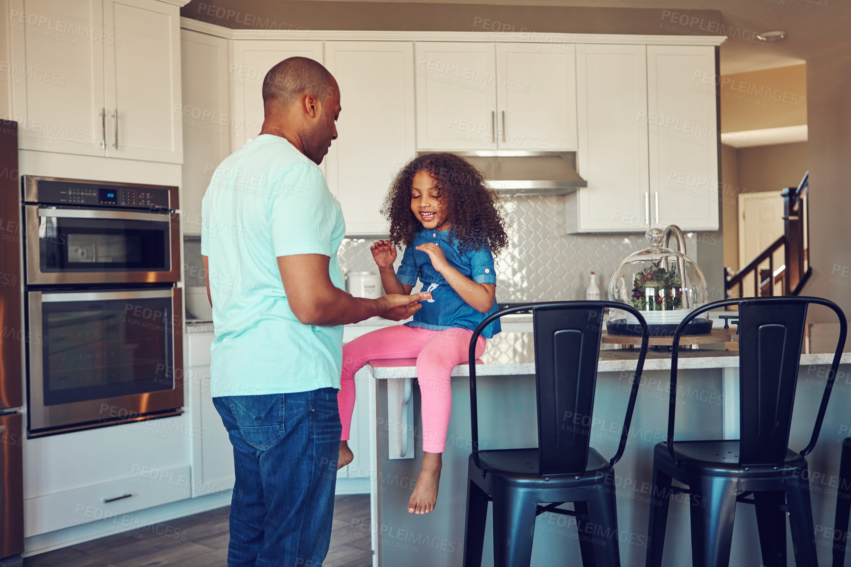 Buy stock photo Shot of a happy little girl and her father bonding in the kitchen at home