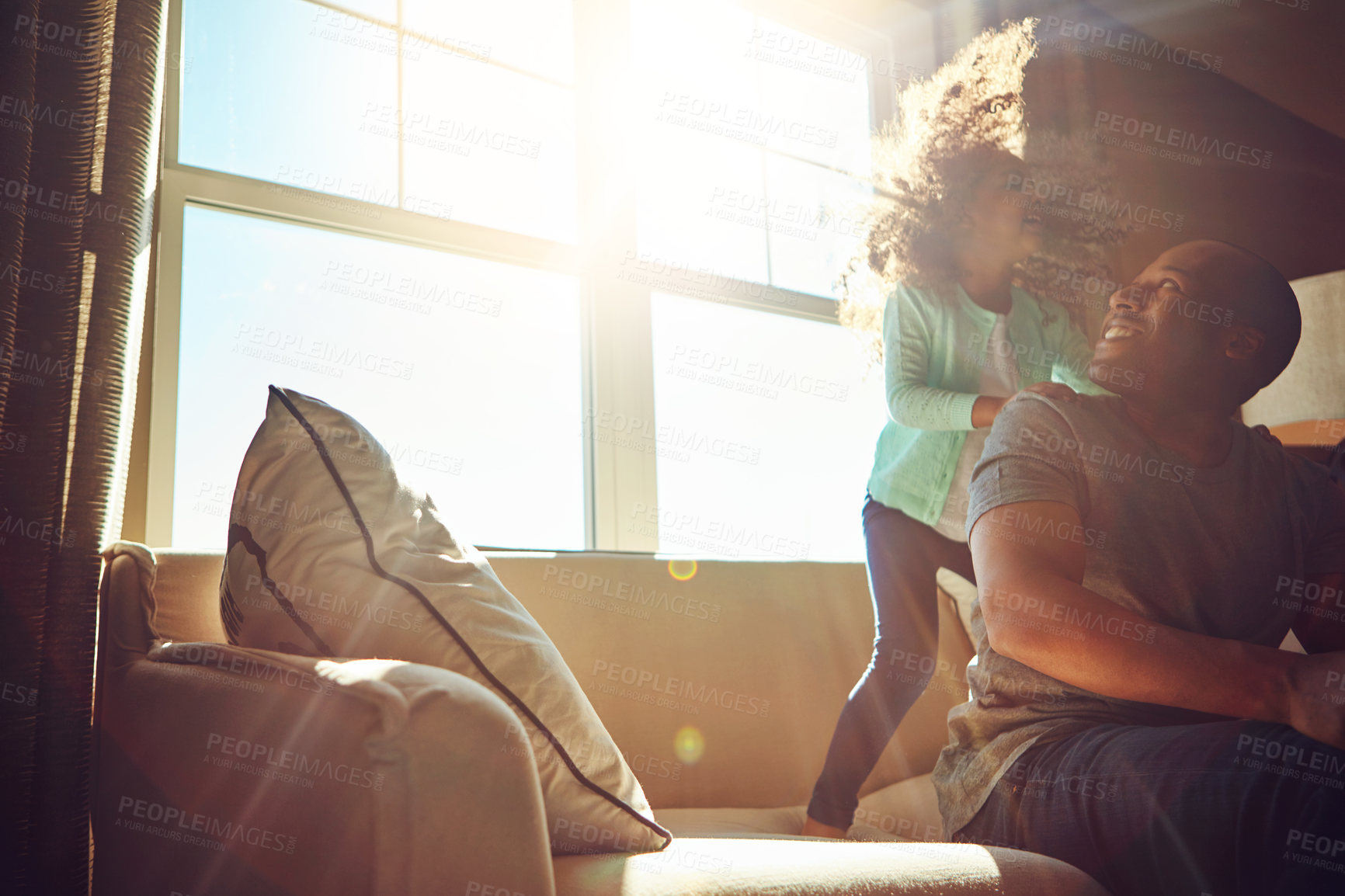 Buy stock photo Playful, man and kid with smile on sofa in living room for care, love or gratitude on fathers day. Sunshine, black family and little girl with dad at home for weekend, happiness or bonding together