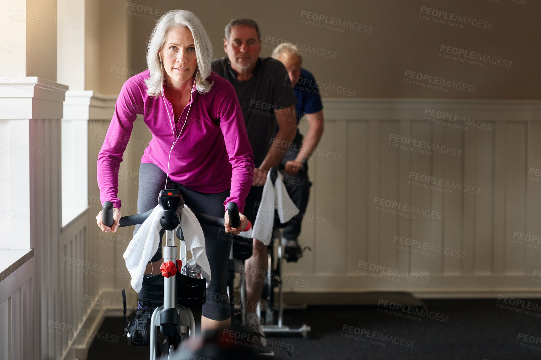 Buy stock photo Spinning class, portrait or senior woman on bike machine in workout or training for health or wellness. Podcast, earphones or elderly female person on cycling exercise for fitness, challenge or music