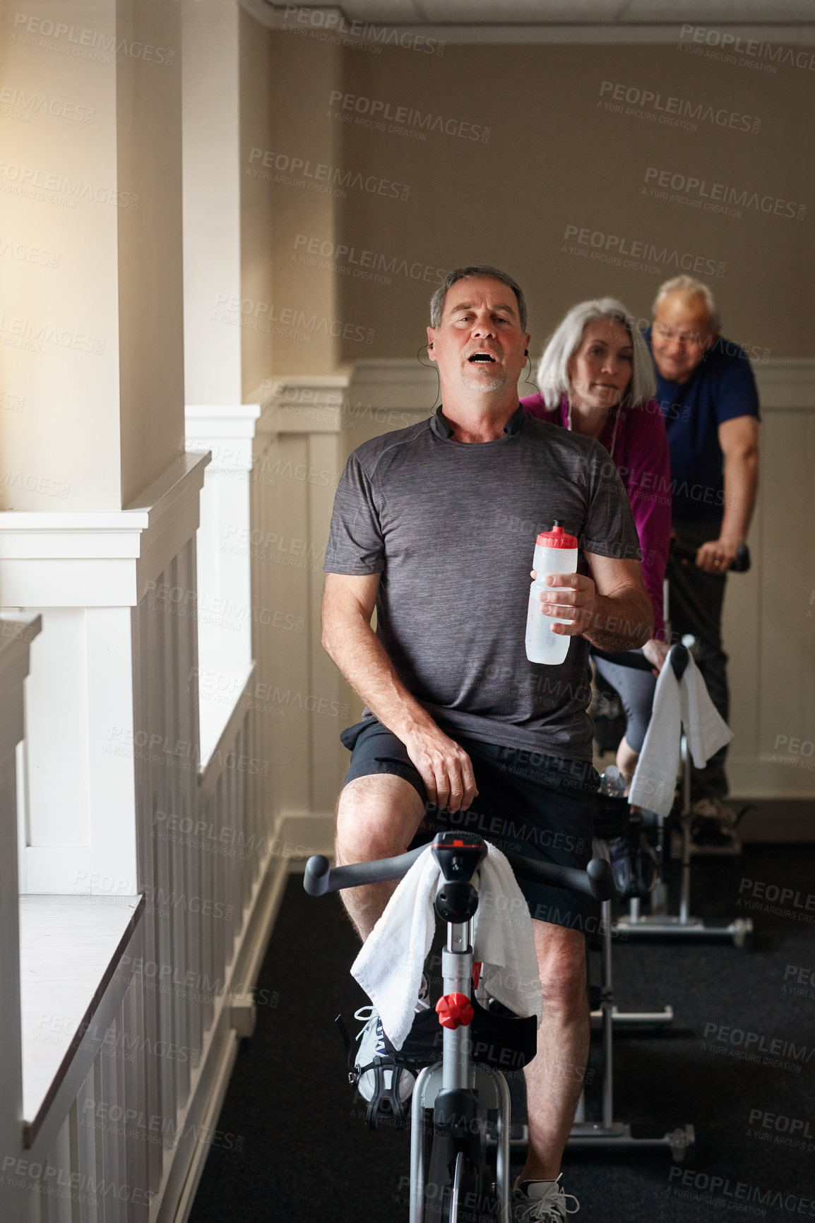 Buy stock photo Tired, mature or man on cycling bike in workout or cardio training for energy, health or wellness. Water, fatigue or exhausted sports person on bicycle machine for fitness, gym challenge or exercise