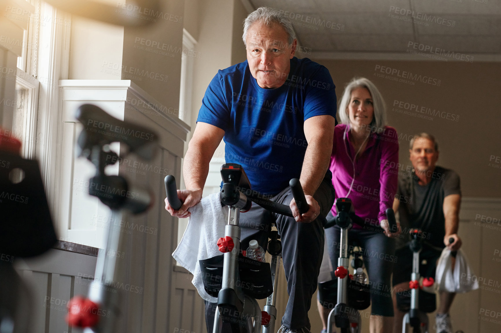 Buy stock photo Fitness, bike class and senior man in gym for cycling, exercise and training with physical activity. Workout club, people and team on spinning machine for health, wellness and endurance with cardio