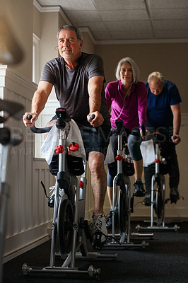 Buy stock photo Shot of a group of seniors having a spinning class at the gym