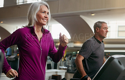 Buy stock photo Shot of a mature woman and man exercising on treadmills at the gym