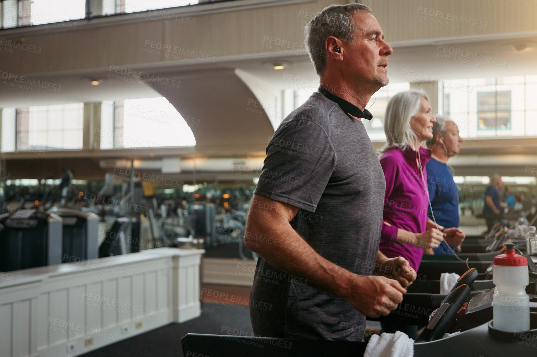 Buy stock photo Running, gym or mature man on treadmill in workout or training for group class, health or cardio wellness. Runner, energy and male person on machine for fitness performance, challenge and exercise