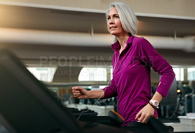 Buy stock photo Shot of a mature woman exercising on a treadmill at the gym