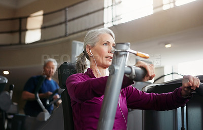 Buy stock photo Mature woman, chest press and music with machine for fitness, workout or indoor exercise at gym. Active female person with earphones on equipment for strength, muscle or wellness at health club