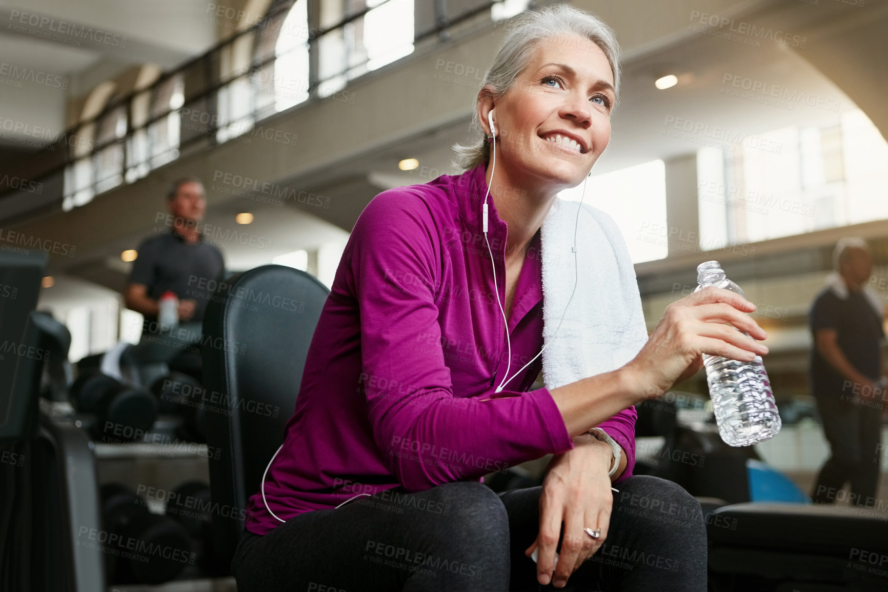 Buy stock photo Portrait of a happy senior woman holding a water bottle and taking a break from her workout at the gym