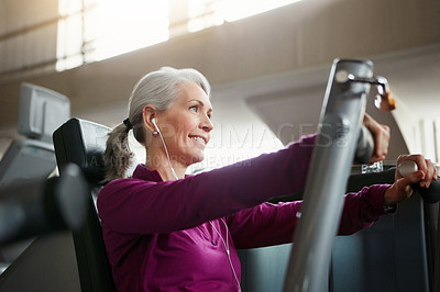 Buy stock photo Portrait of a happy senior woman working out with a chest press at the gym