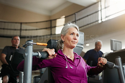 Buy stock photo Portrait of a senior woman working out with a chest press at the gym
