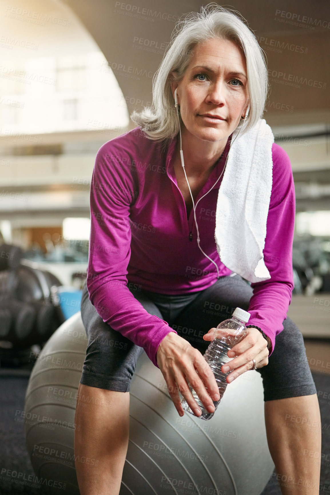 Buy stock photo Relax, exercise and portrait of mature woman with pride, fitness and commitment with water bottle at workout. Gym, training and confident athlete on break with earphones, health or wellness in sports