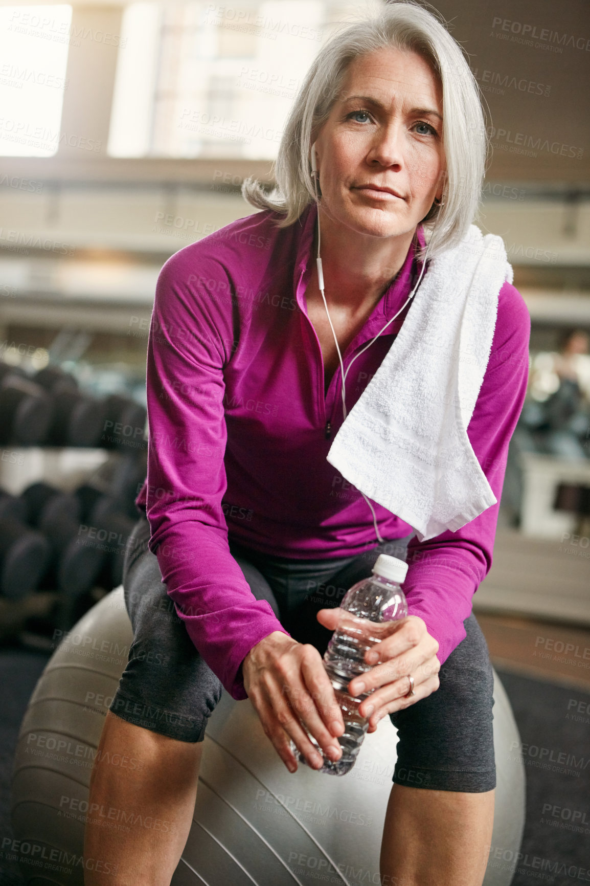 Buy stock photo Relax, portrait of mature woman with workout, fitness and pride with water bottle on gym ball. Exercise, training and confident female athlete on break with earphones, health and wellness in club.