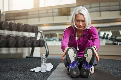 Buy stock photo Shot of a mature woman working out at the gym