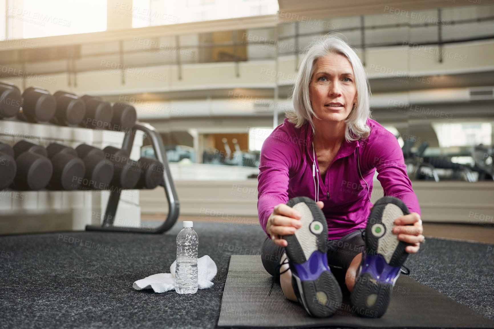 Buy stock photo Mature woman, warm up and legs on gym floor, stretching and challenge for progress in workout. Person, muscle and start training for wellness with development, ready and exercise mat at fitness club