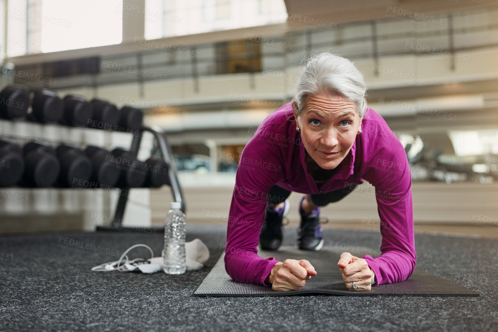 Buy stock photo Mature woman, plank and exercise on gym floor with balance for core muscle with vision for wellness. Person, training and workout for abdomen, stomach and challenge for development at fitness club