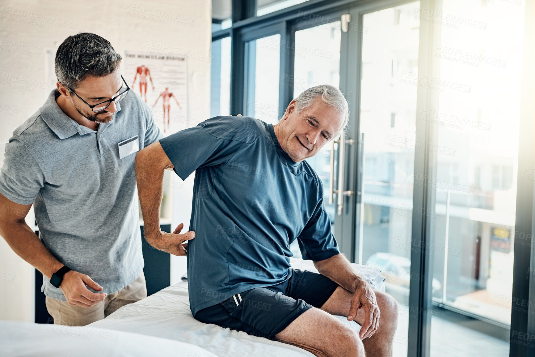 Buy stock photo Shot of a skilled physiotherapist addressing his mature patient's back pain in the rehabilitation center