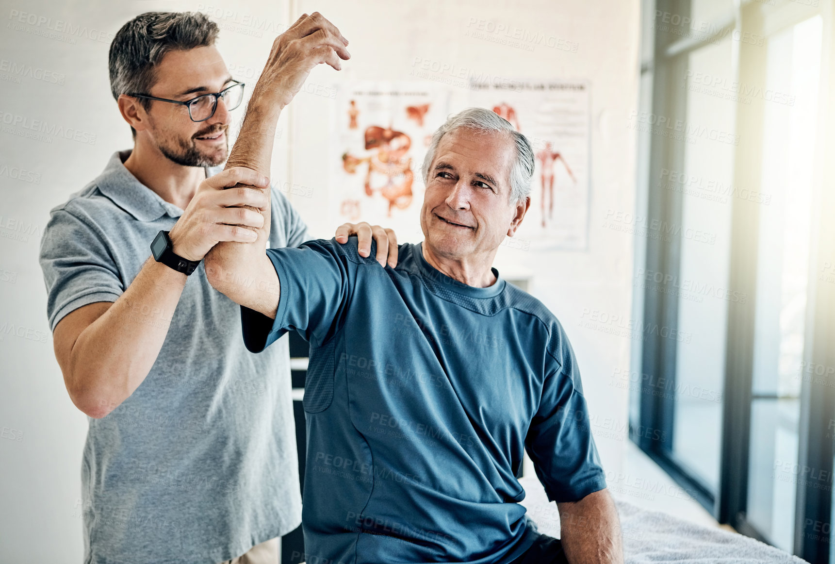 Buy stock photo Shot of a skilled physiotherapist testing his mature patient's mobility in the rehabilitation center