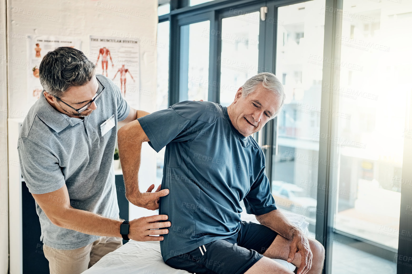 Buy stock photo Shot of a skilled physiotherapist addressing his mature patient's back pain in the rehabilitation center