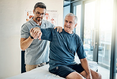 Buy stock photo Shot of a skilled physiotherapist testing his mature patient's mobility in the rehabilitation center