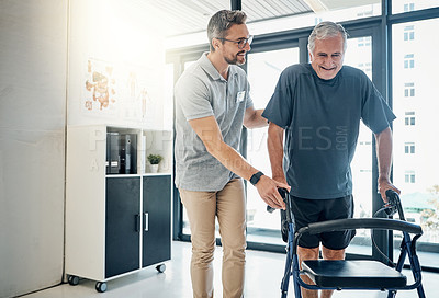 Buy stock photo Shot of a caring physiotherapist helping his mature patient to use a walker at the rehabilitation center