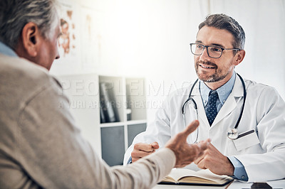 Buy stock photo Shot of a friendly doctor consulting with a mature patient in his office